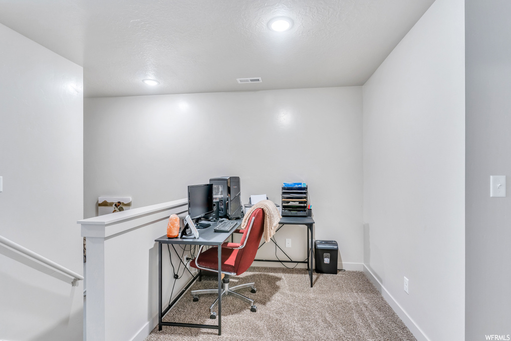 Office area with light carpet and a textured ceiling