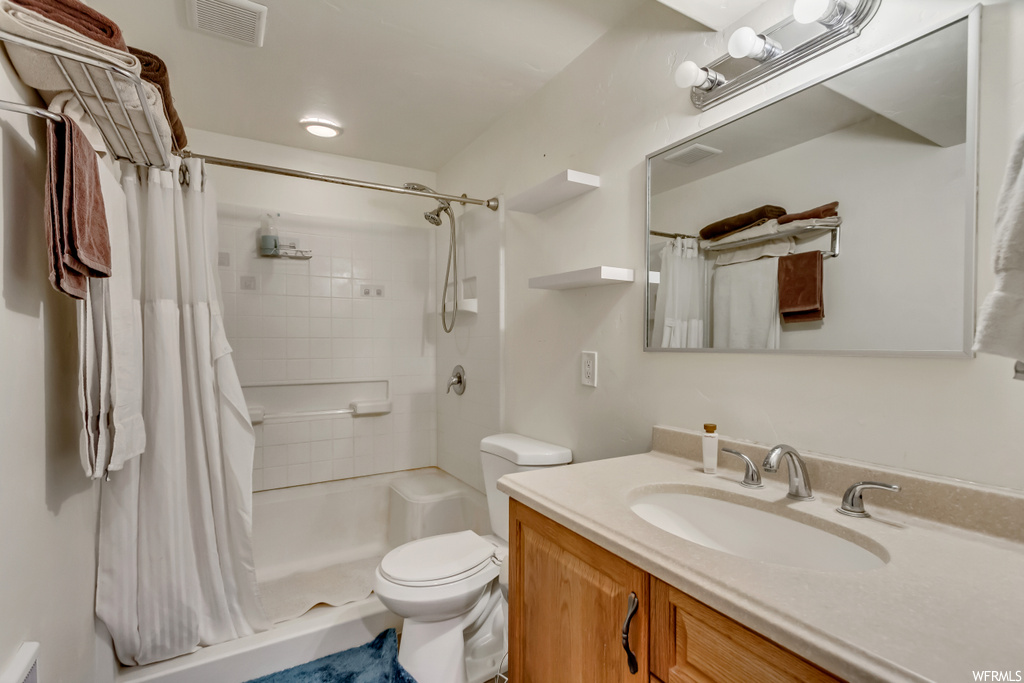 Bathroom featuring a shower with shower curtain, large vanity, and mirror