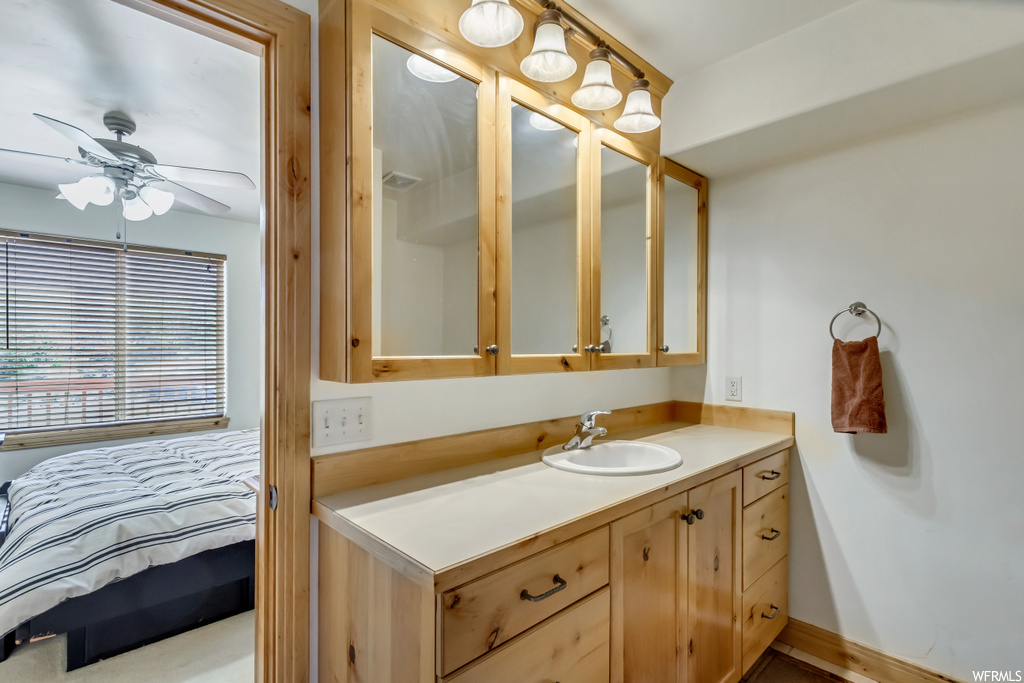 Bathroom with vanity, mirror, and ceiling fan