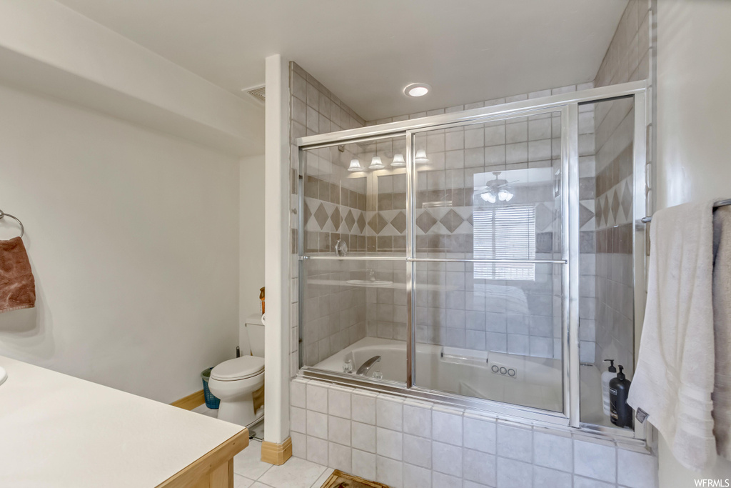 Full bathroom featuring vanity, light tile flooring, and shower / bath combination with glass door