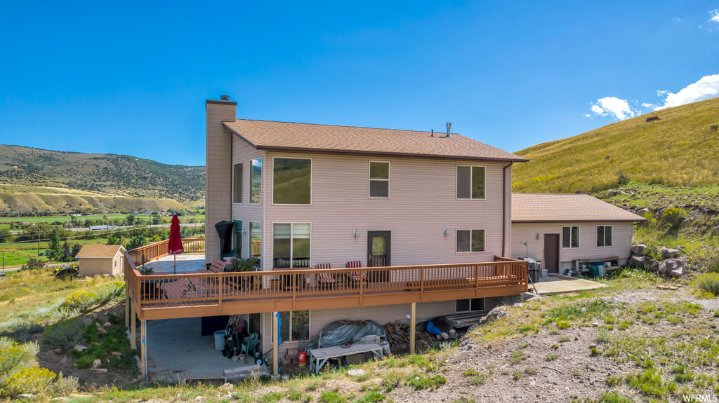 Rear view of property with a patio and a deck with mountain view