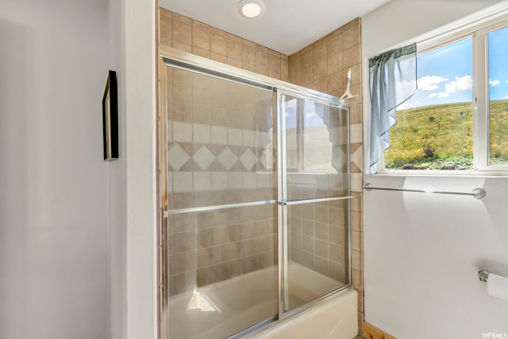 Bathroom with shower / bath combination with glass door