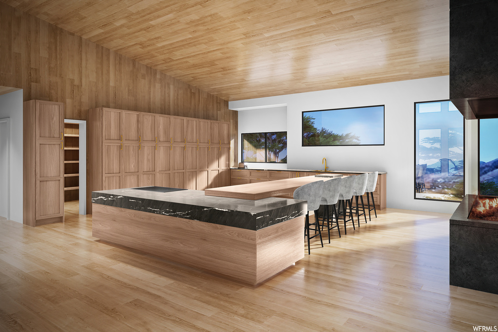 Kitchen with wood ceiling, a kitchen island, light hardwood floors, and a high ceiling
