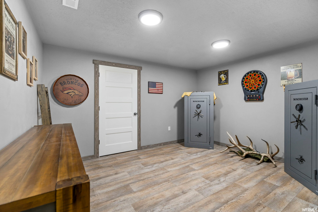 Misc room with light hardwood flooring and a textured ceiling