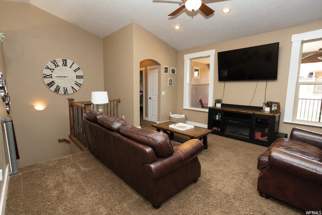 Living room with carpet floors, vaulted ceiling, and ceiling fan
