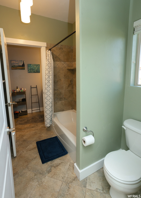 Bathroom with light tile flooring and shower / tub combo
