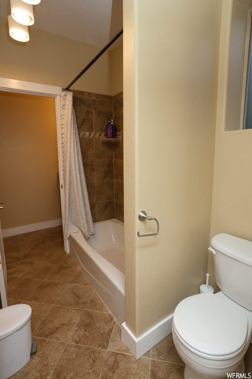 Bathroom featuring shower / tub combo and light tile floors