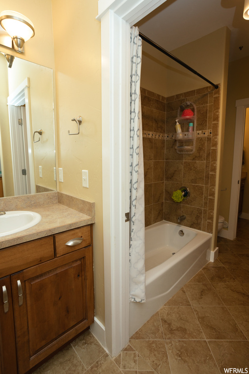 Full bathroom featuring vanity, shower / bath combination with curtain, mirror, and light tile flooring