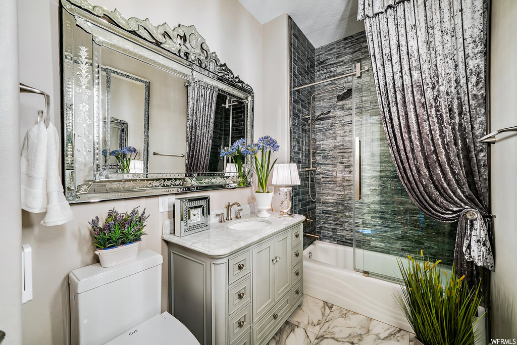 Full bathroom featuring tile floors, vanity, mirror, and shower / bath combination with glass door