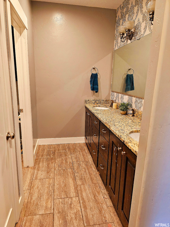 Bathroom with light tile floors, mirror, and double large sink vanity