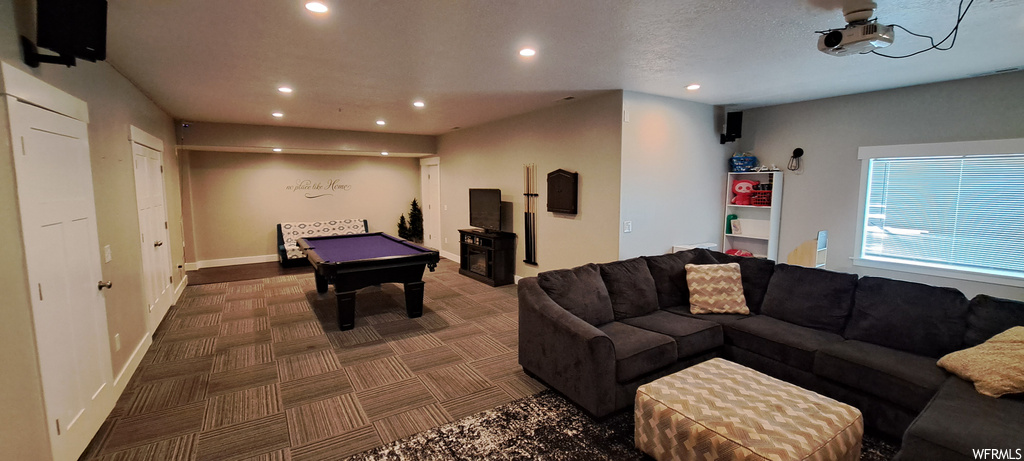Recreation room with a textured ceiling and dark carpet