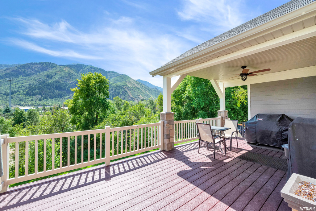 Wooden deck with a mountain view and ceiling fan