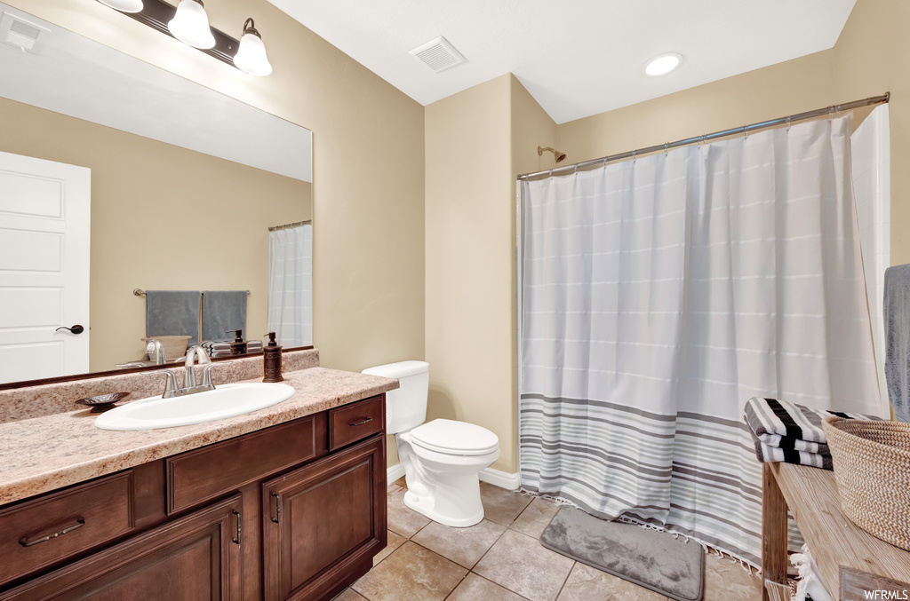 Full bathroom featuring shower / tub combo, large vanity, mirror, and light tile floors