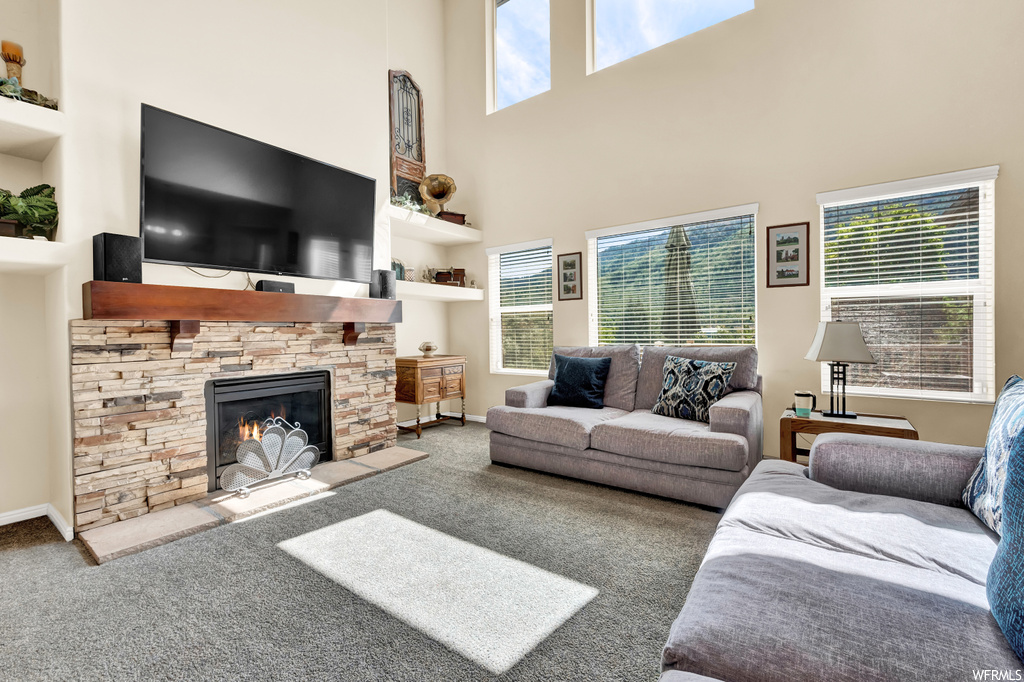 Carpeted living room with a fireplace and built in shelves