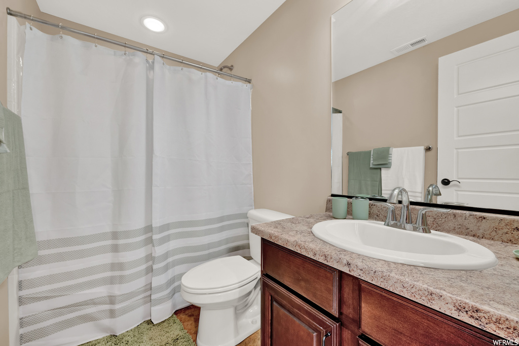 Bathroom featuring vanity, mirror, and light tile flooring