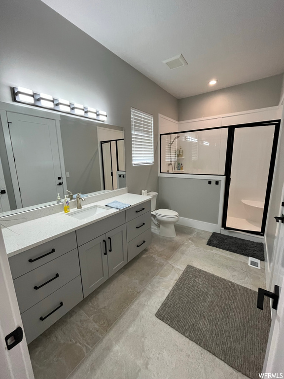Bathroom featuring oversized vanity, tile floors, mirror, and a shower with door