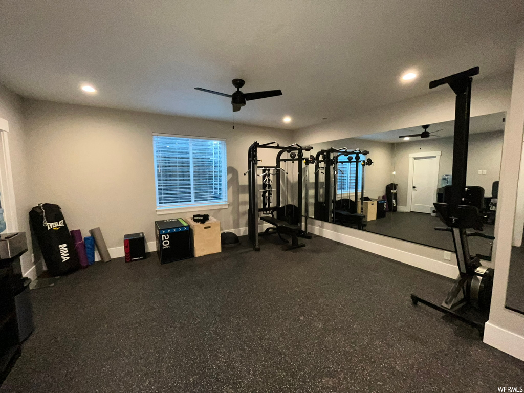 Exercise room with ceiling fan and a textured ceiling
