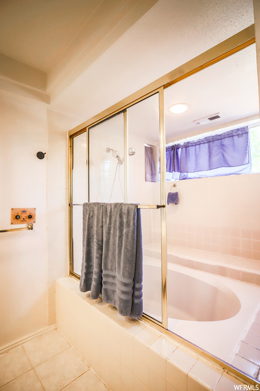 Bathroom featuring an enclosed shower and light tile floors