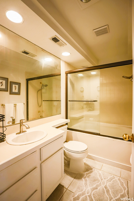Full bathroom featuring oversized vanity, enclosed tub / shower combo, mirror, and light tile floors