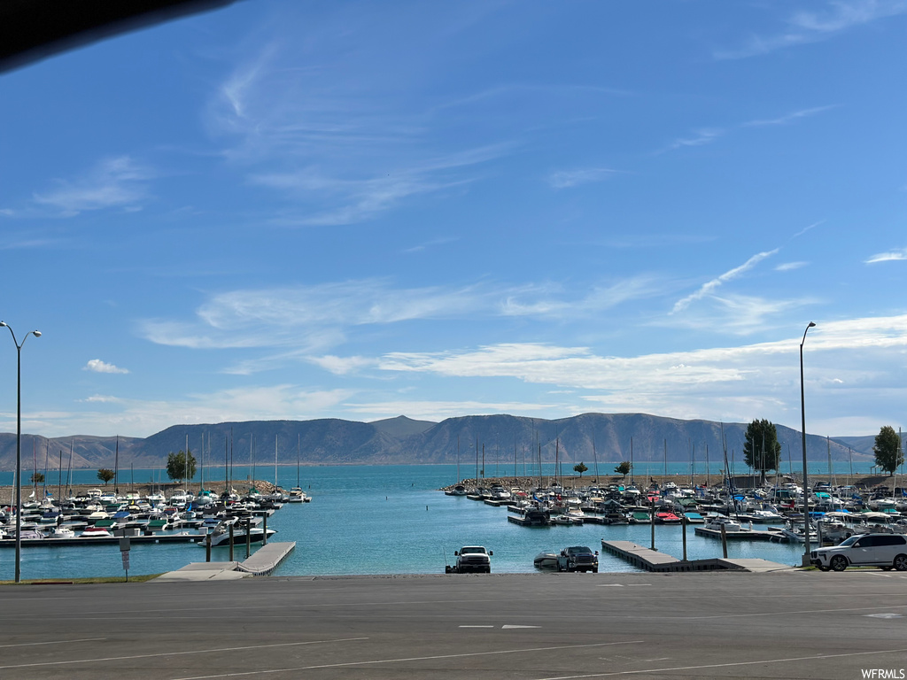 Water view featuring a mountain view and a dock