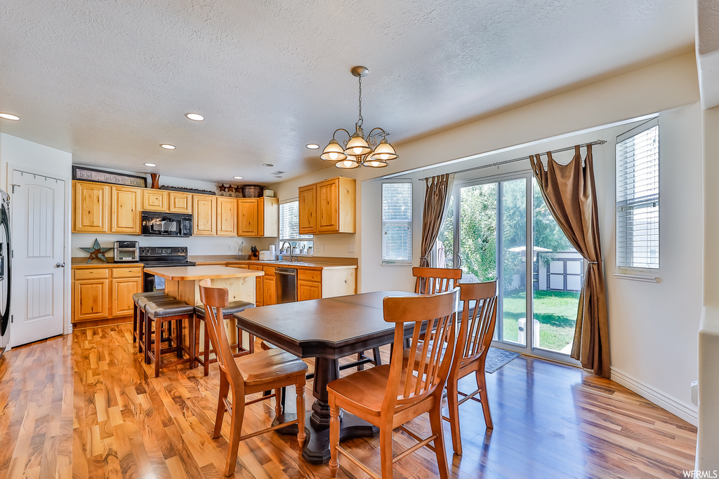 Wood floored dining area with a wealth of natural light and a textured ceiling
