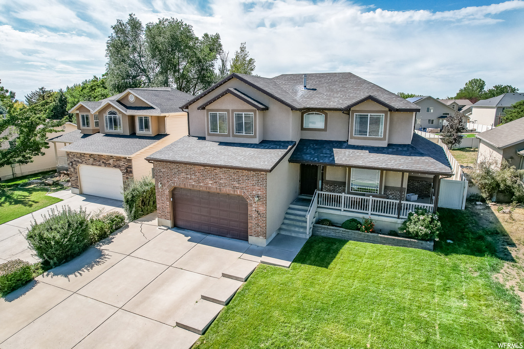 View of front of property with garage, a porch, and a front yard