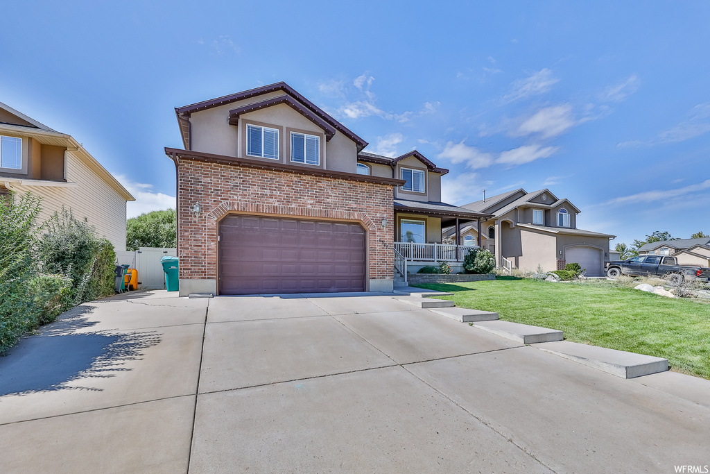 View of front of house featuring garage and a front lawn