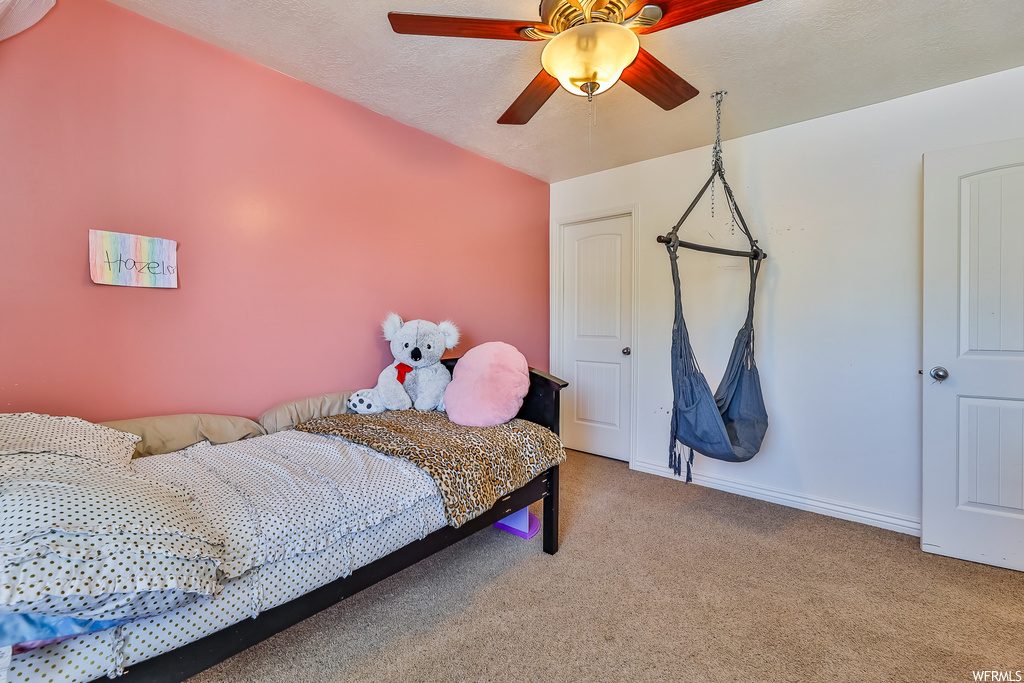 Carpeted bedroom featuring ceiling fan