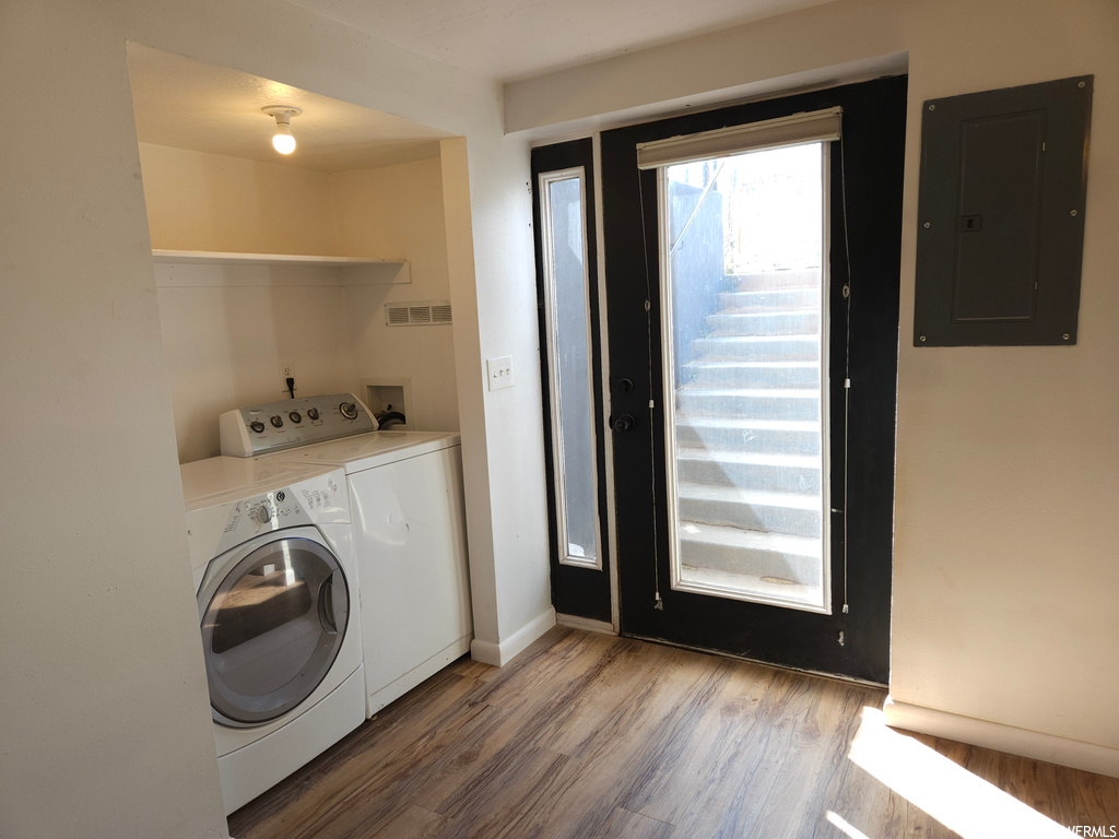 Laundry room featuring light hardwood flooring and washer and dryer