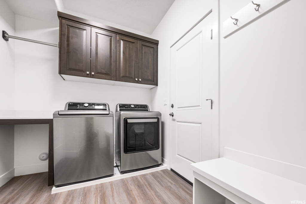 Laundry room featuring light hardwood flooring and washing machine and clothes dryer