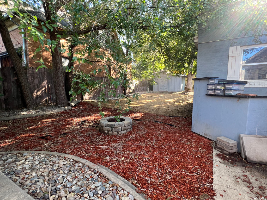 View of yard featuring a storage unit and a firepit