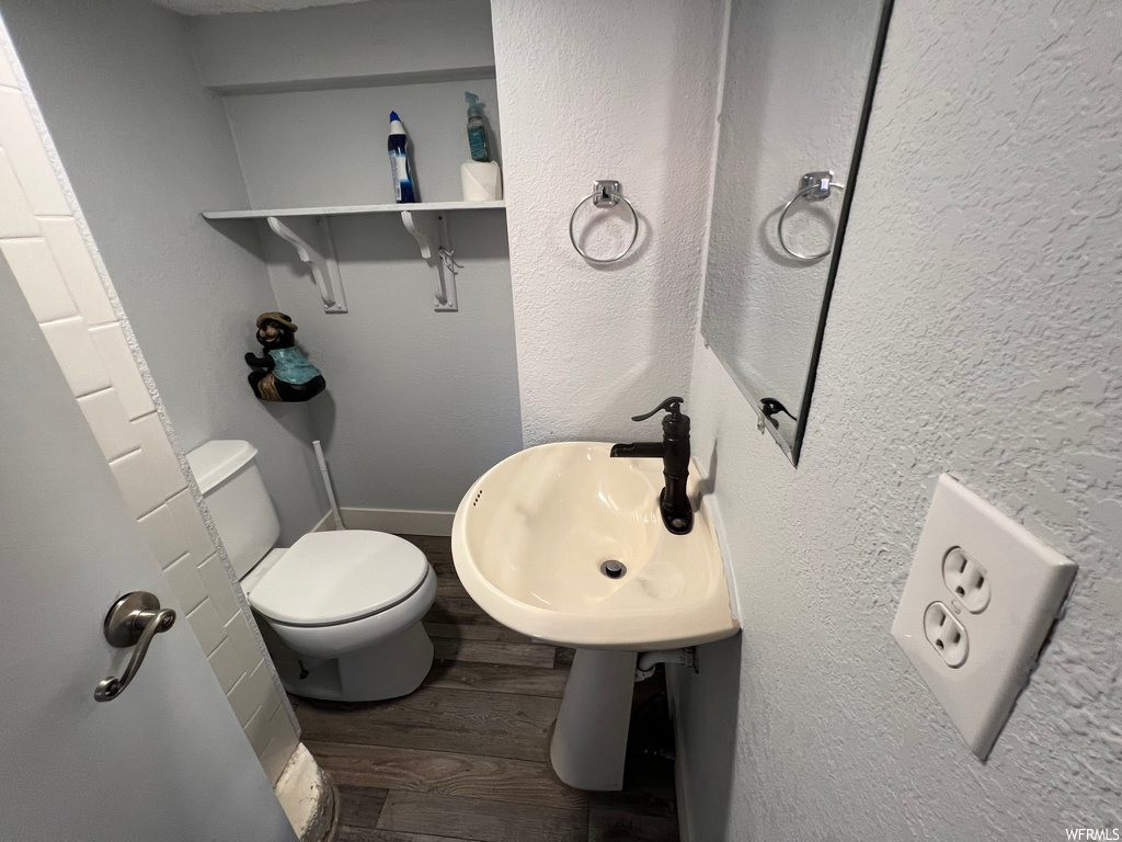 Bathroom with washbasin and dark hardwood flooring