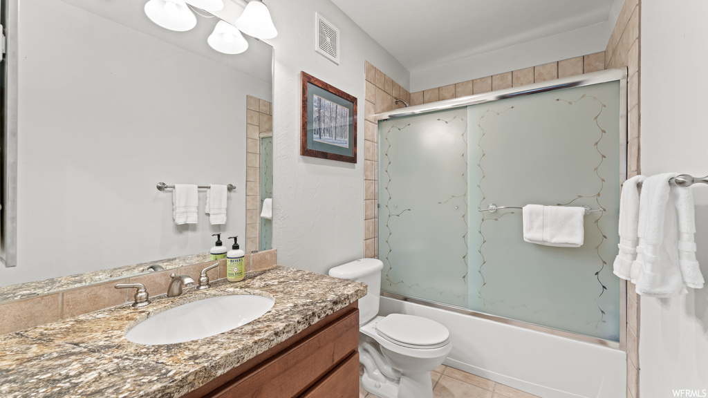 Full bathroom with vanity, enclosed tub / shower combo, mirror, and light tile floors