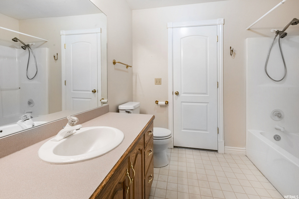 Full bathroom with light tile flooring, shower / washtub combination, mirror, and vanity