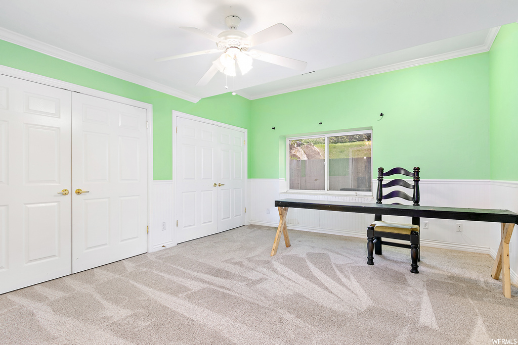 Carpeted office space featuring crown molding and ceiling fan