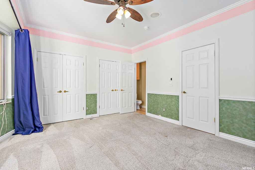 Bedroom with ornamental molding, light carpet, and ceiling fan