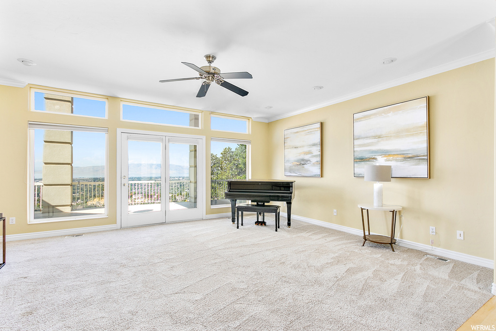 Miscellaneous room featuring light carpet, ornamental molding, and ceiling fan