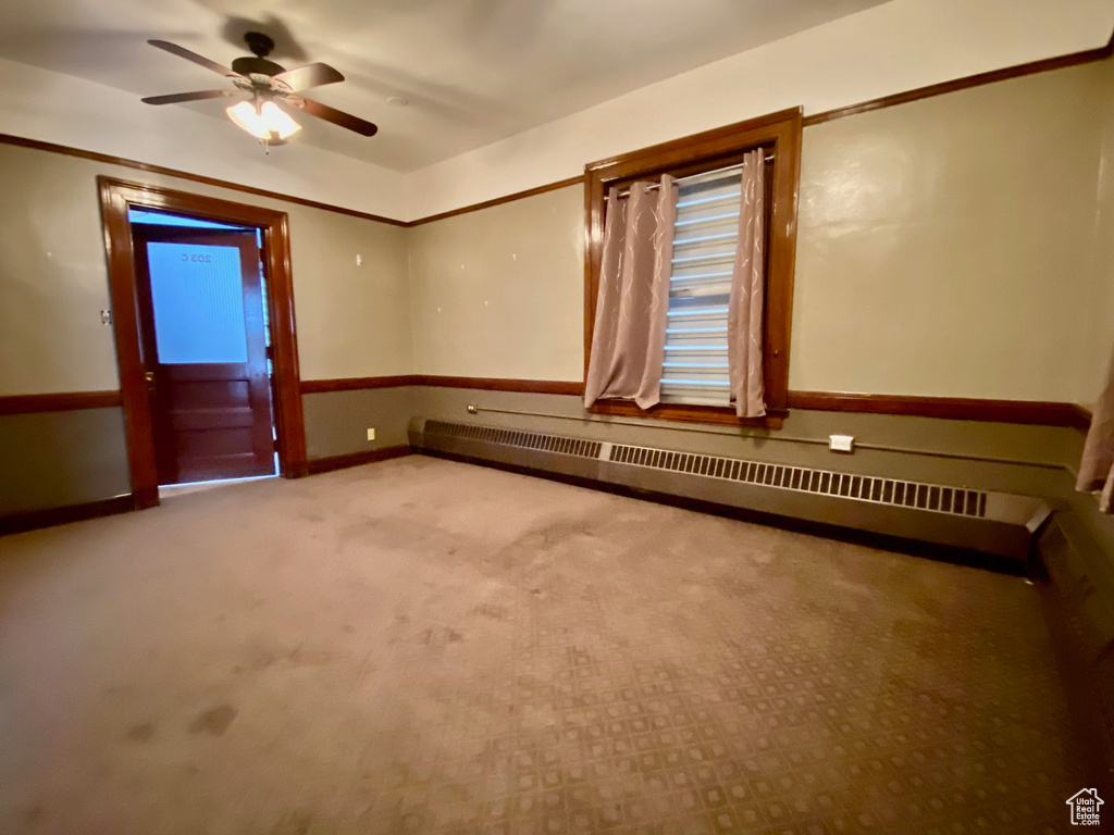 Unfurnished room with a baseboard heating unit, carpet floors, and ceiling fan