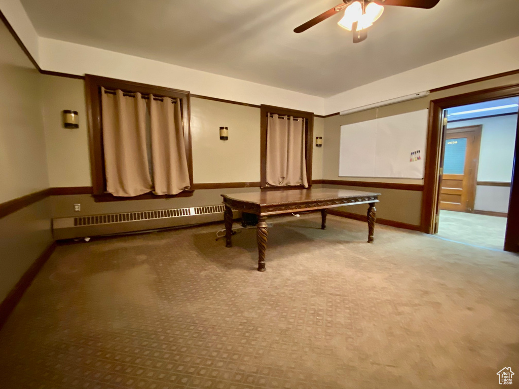 Playroom with a baseboard heating unit, ceiling fan, and light carpet