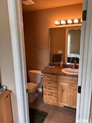 Bathroom with tile flooring, mirror, and vanity