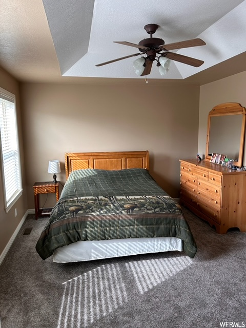 Bedroom with a textured ceiling, carpet, and ceiling fan