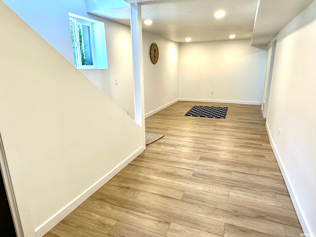 Basement with light hardwood flooring