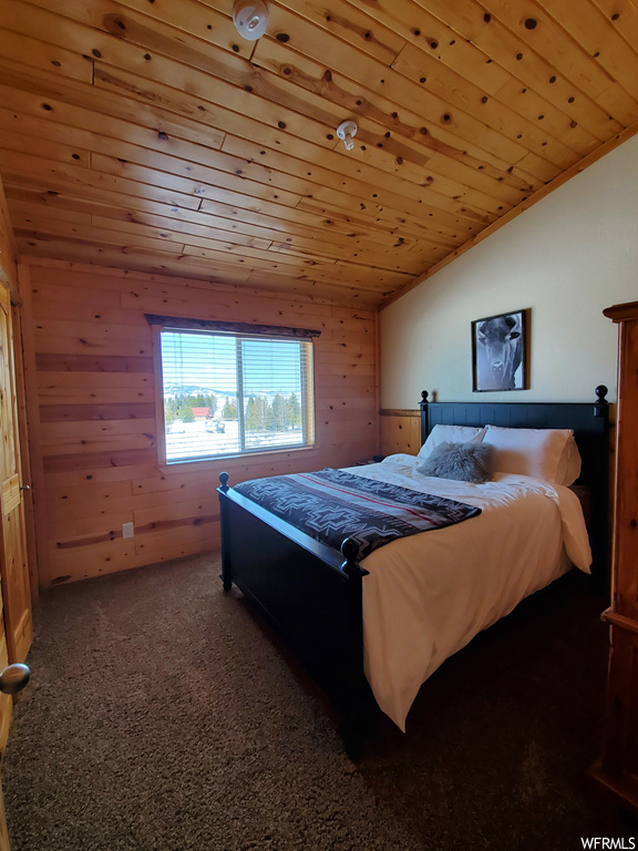 Bedroom with wood walls, wooden ceiling, carpet floors, and vaulted ceiling