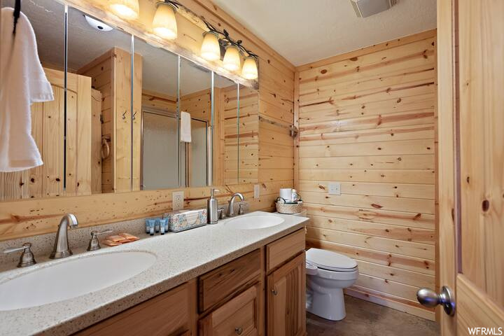 Bathroom with wood walls, mirror, and dual large bowl vanity