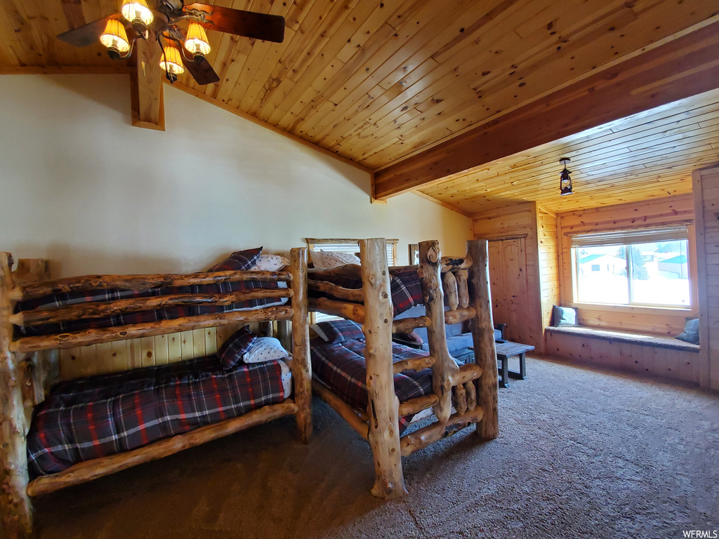 Bedroom featuring lofted ceiling with beams, carpet flooring, ceiling fan, and wooden ceiling