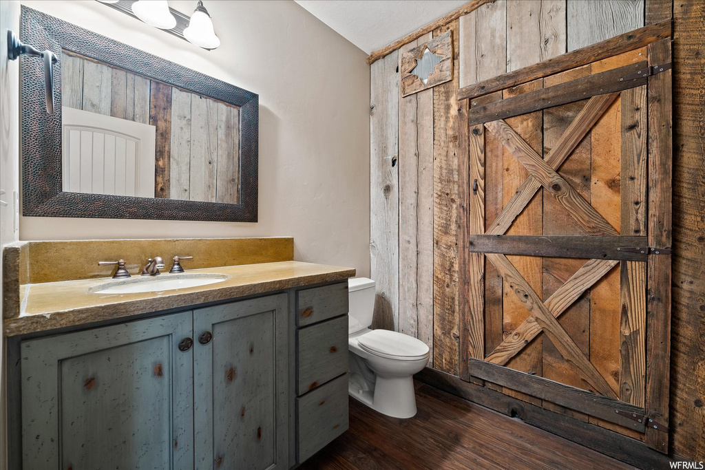 Bathroom with dark hardwood floors, mirror, and vanity