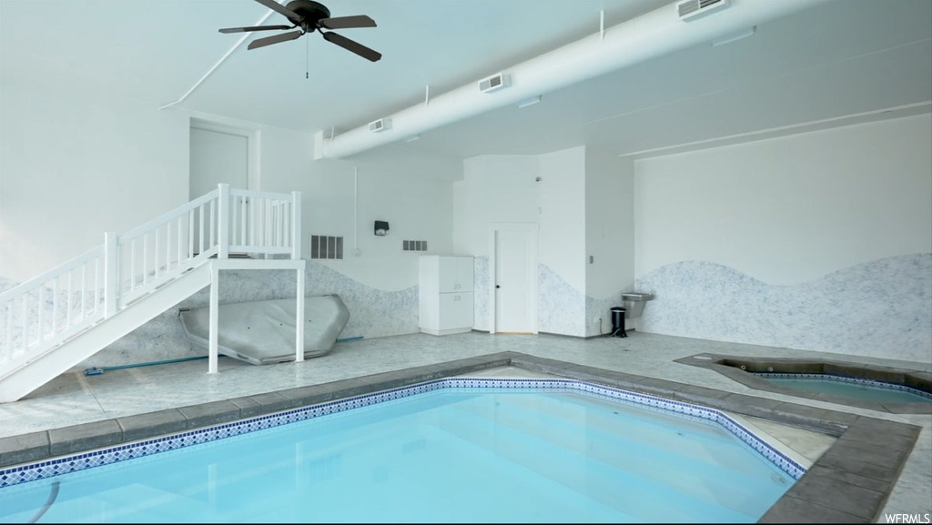 View of swimming pool featuring hot tub and ceiling fan
