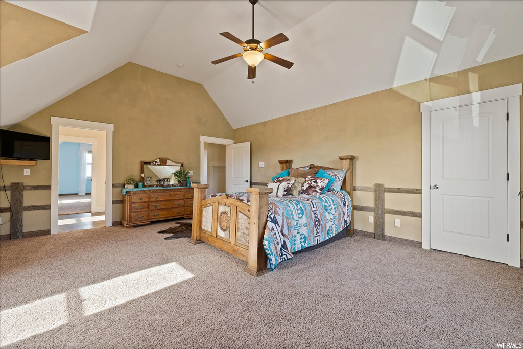 Carpeted bedroom with a high ceiling and lofted ceiling