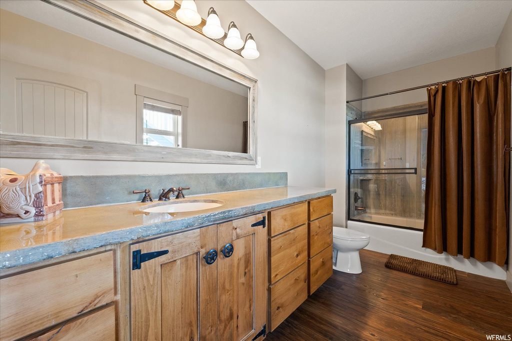 Full bathroom with shower / tub combo with curtain, hardwood floors, mirror, and vanity