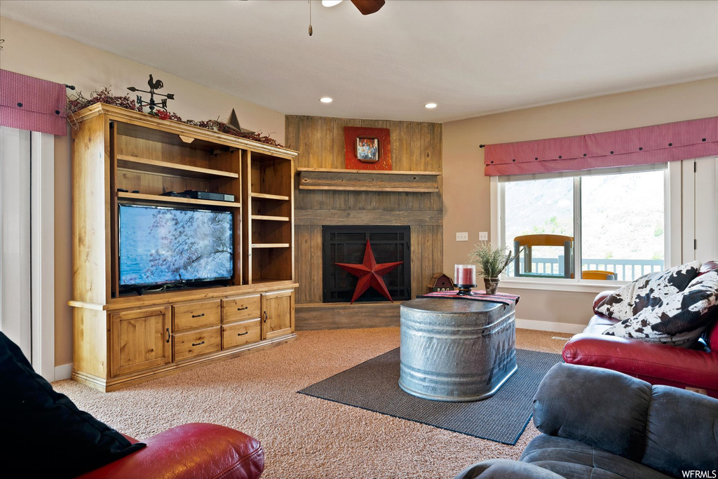 Carpeted living room with wood walls and a fireplace